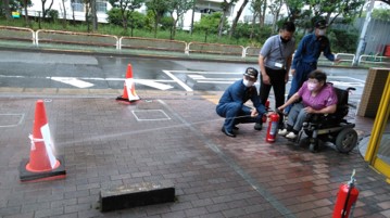 車椅子に座る女性が消火器を実際に扱う様子