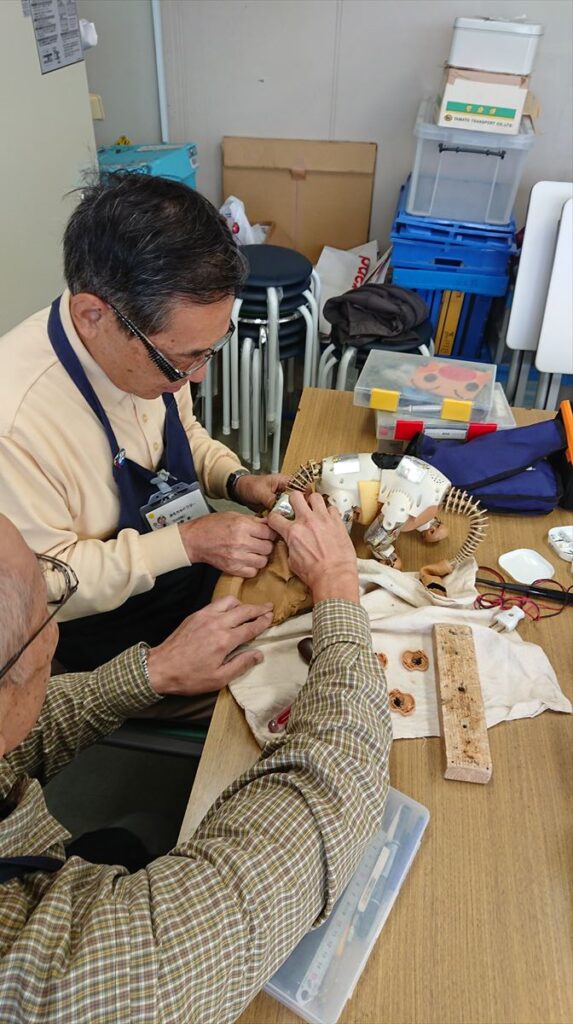 おもちゃを直す男性2人の様子